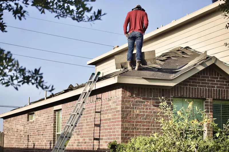 Professional roofer working on a residential roof in Columbia Falls